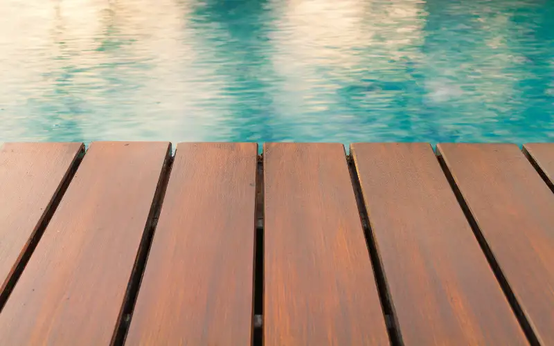 A wooden deck surrounding a pool