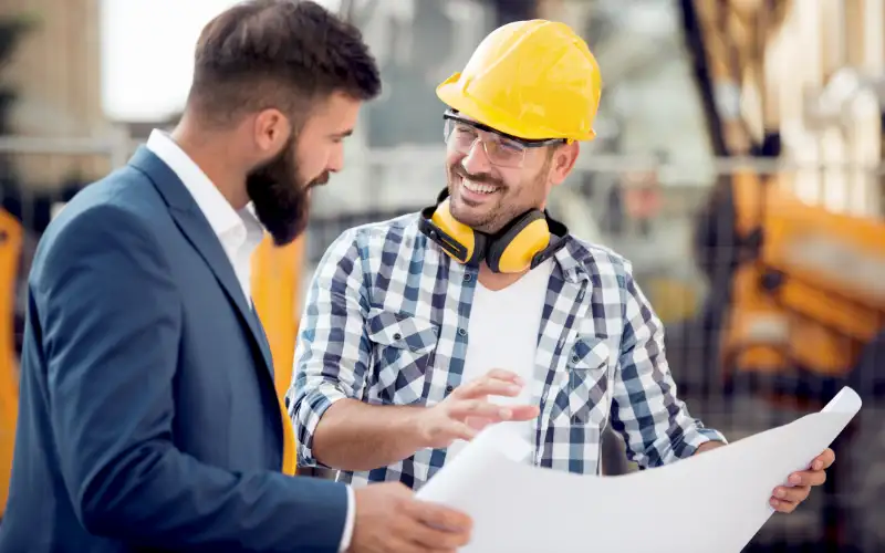 A homeowner consulting a deck builder about his decking plans for his deck installation