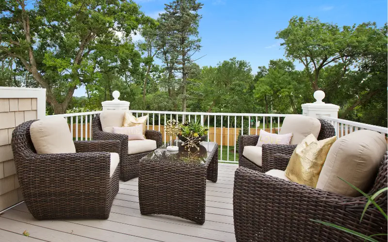 Outdoor furniture on a deck overlooking the trees